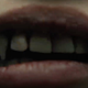 A woman's teeth begin to sprout fangs in this screengrab from Netflix vampire action movie Blood Red Sky.